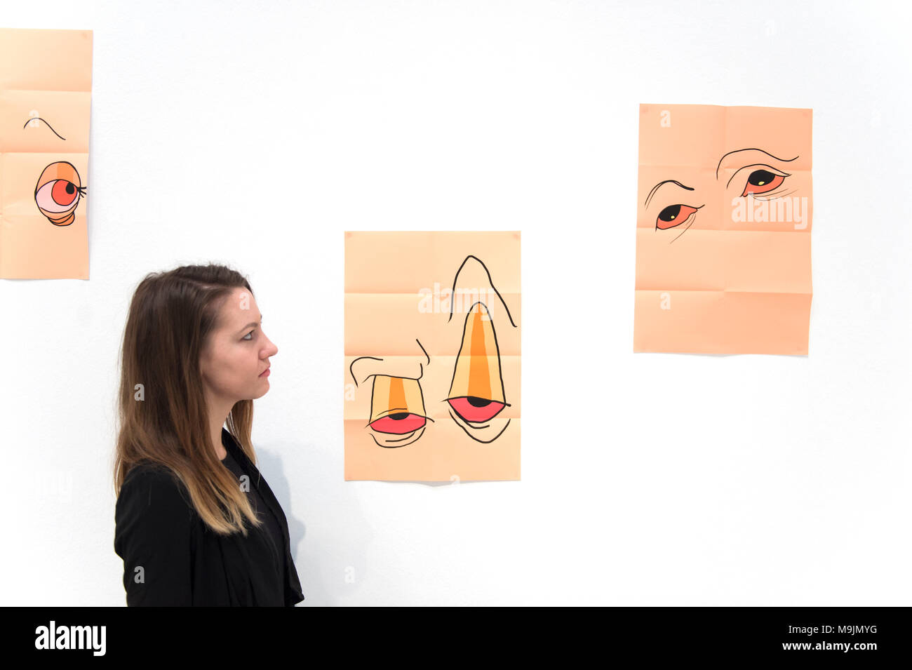 Royal Academy of Arts, Londres, Royaume-Uni. 27 mars 2018. Expositions Projets intérimaire primes nouveau travail par 14 étudiants de deuxième année l'étude sur le programme d'études de trois ans à la Royal Academy Schools, la plus ancienne école d'art. L'exposition comprend un éventail de médias, y compris la peinture, écrits ou audio-visuels, travail avec un accent particulier sur la discipline de la sculpture. Un membre du personnel de la galerie d'exposition examine des oeuvres de Matilda Maures. Credit : Malcolm Park/Alamy Live News. Banque D'Images