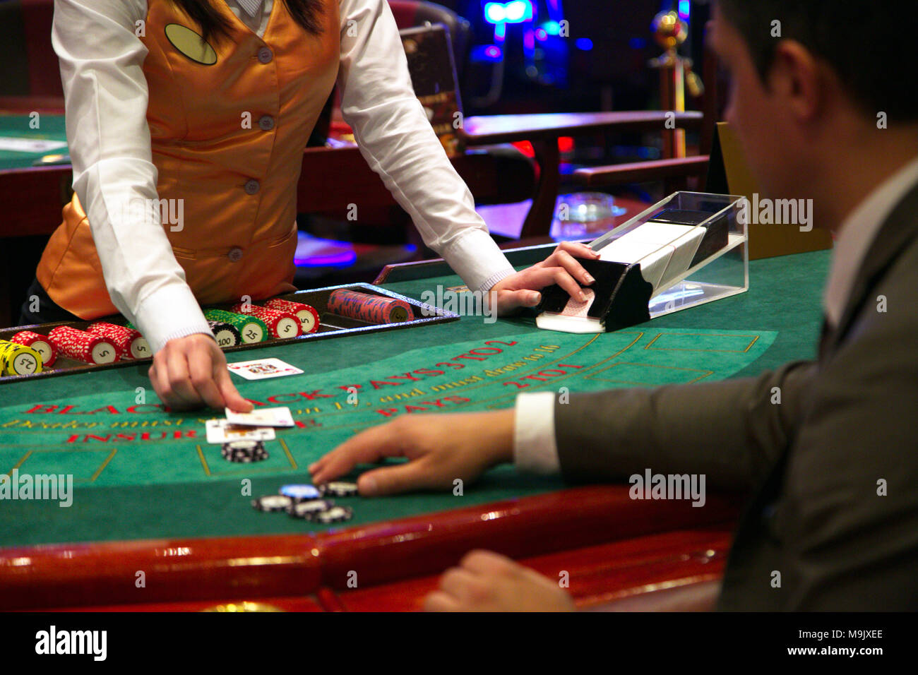 Le concessionnaire met une carte sur table de blackjack Banque D'Images