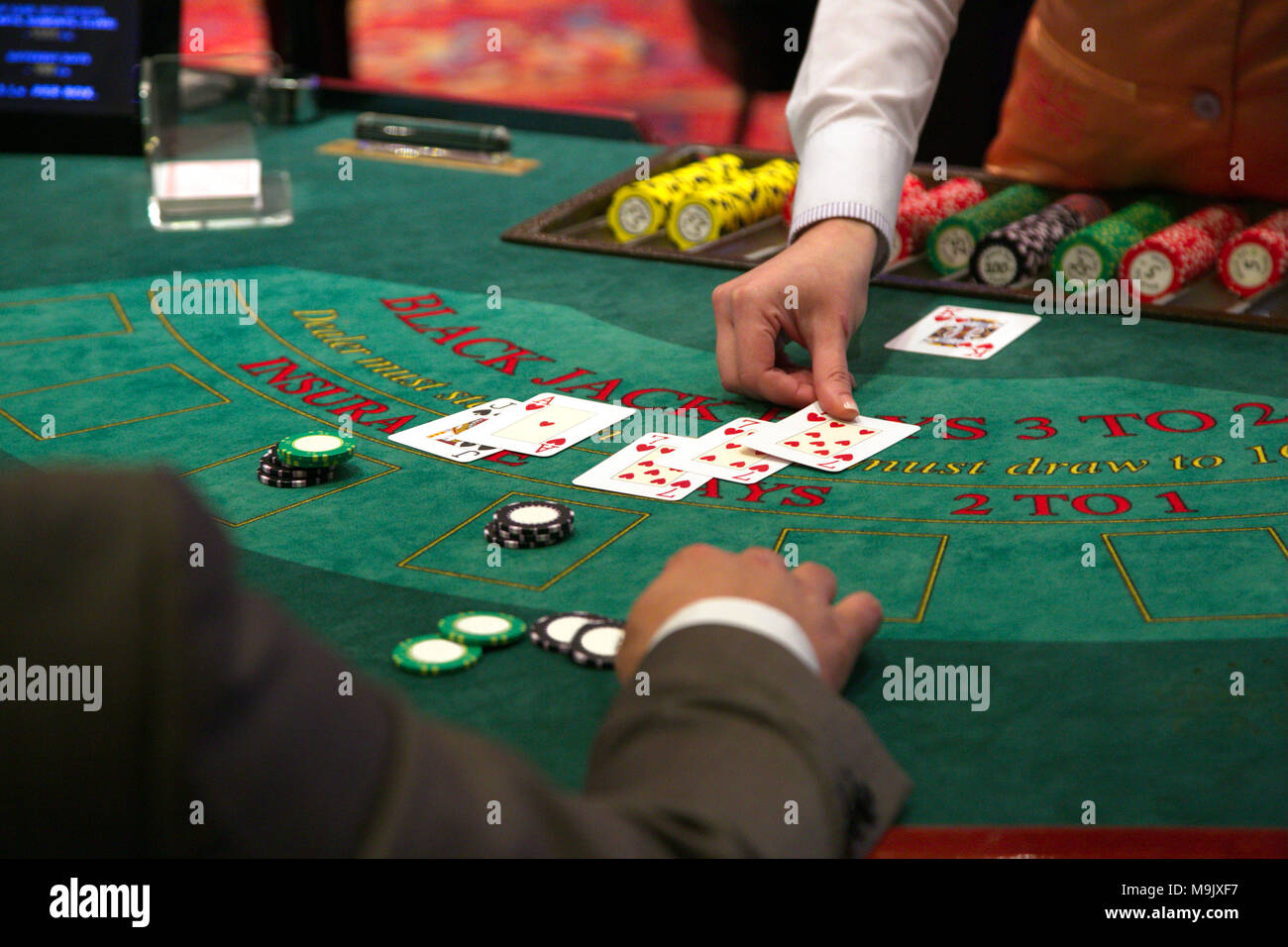 Le concessionnaire met une carte sur table de blackjack Banque D'Images
