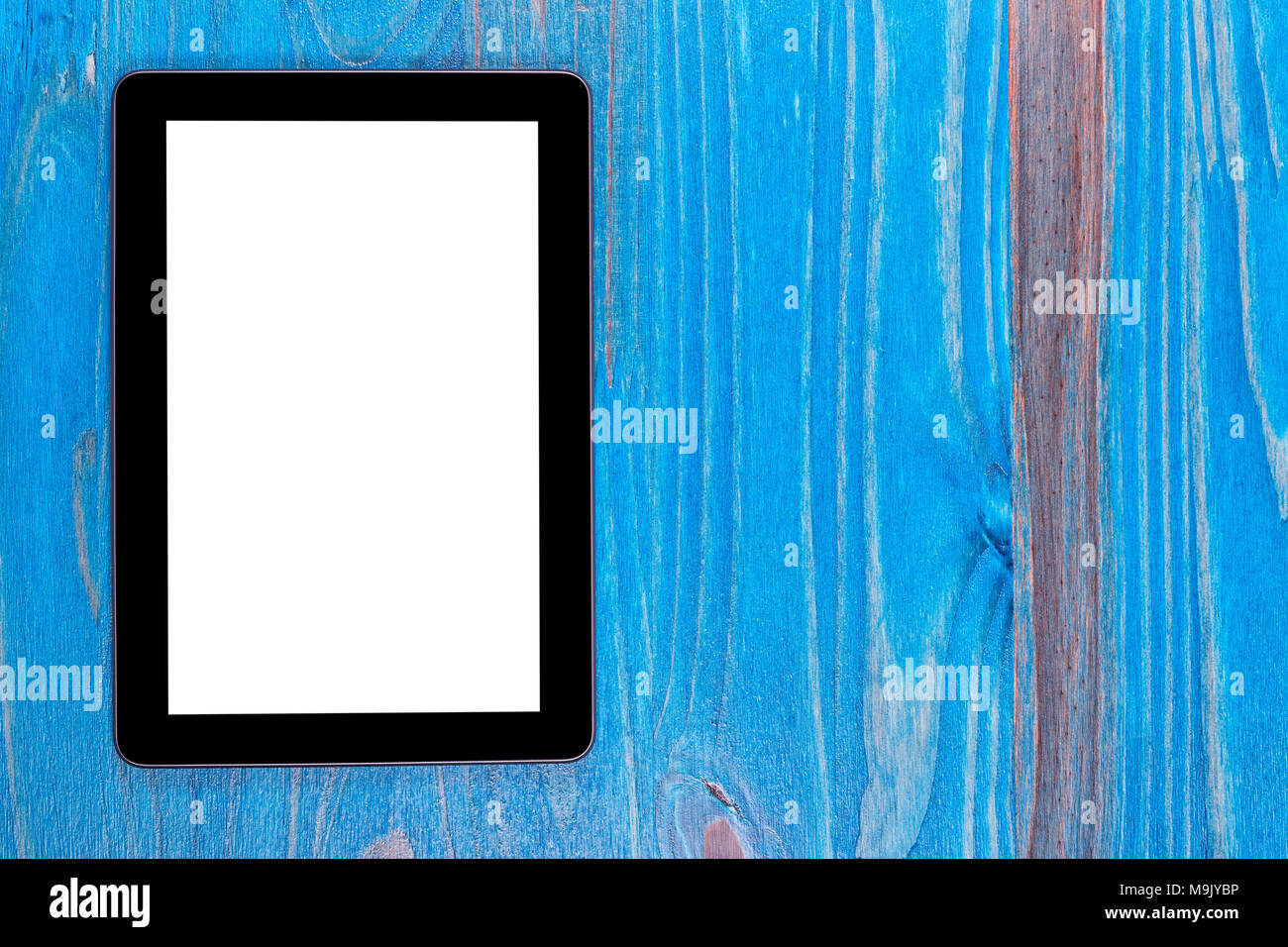 Un modèle de tablette noir avec un écran blanc sur bois peint en bleu. Banque D'Images