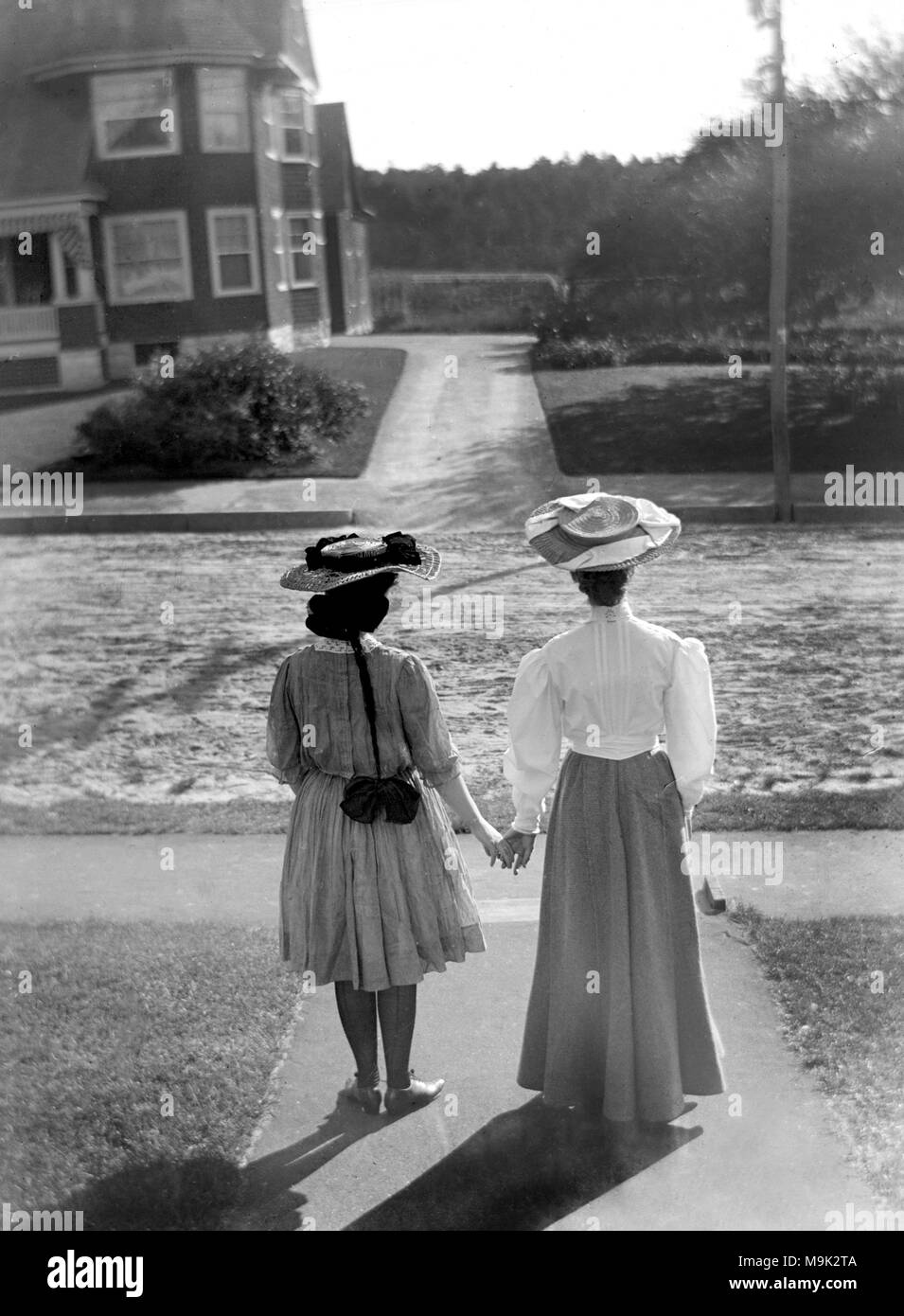 Deux femmes victoriennes visage et tenir la main, ca. 1900. Banque D'Images