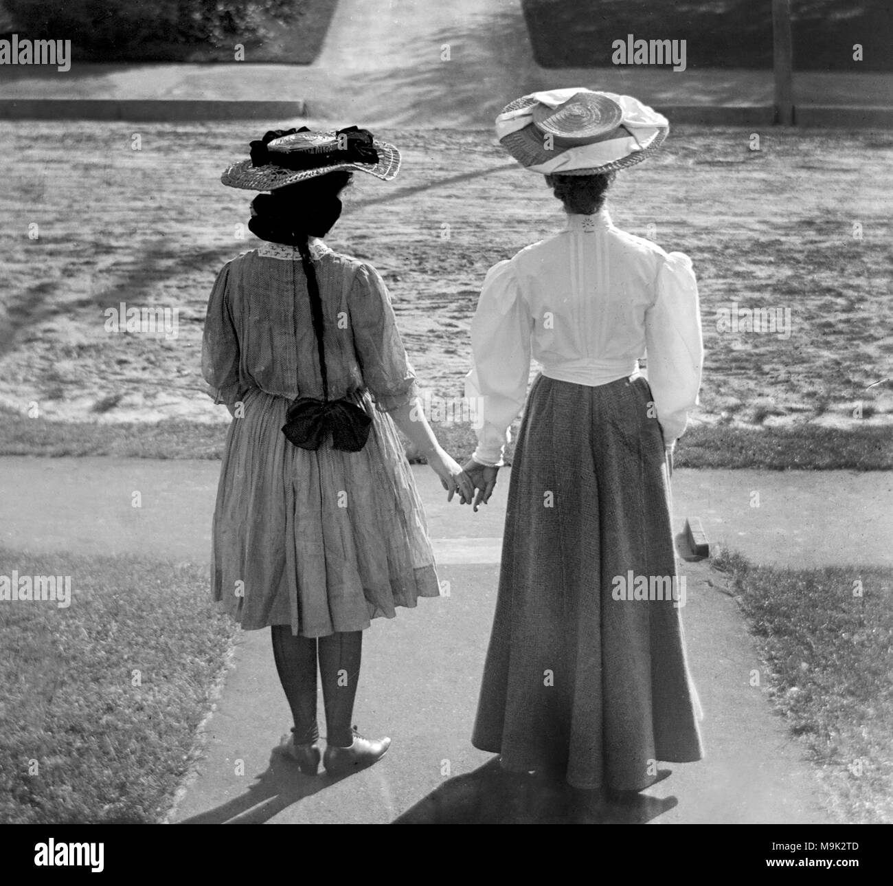 Deux femmes victoriennes visage et tenir la main, ca. 1900. Banque D'Images