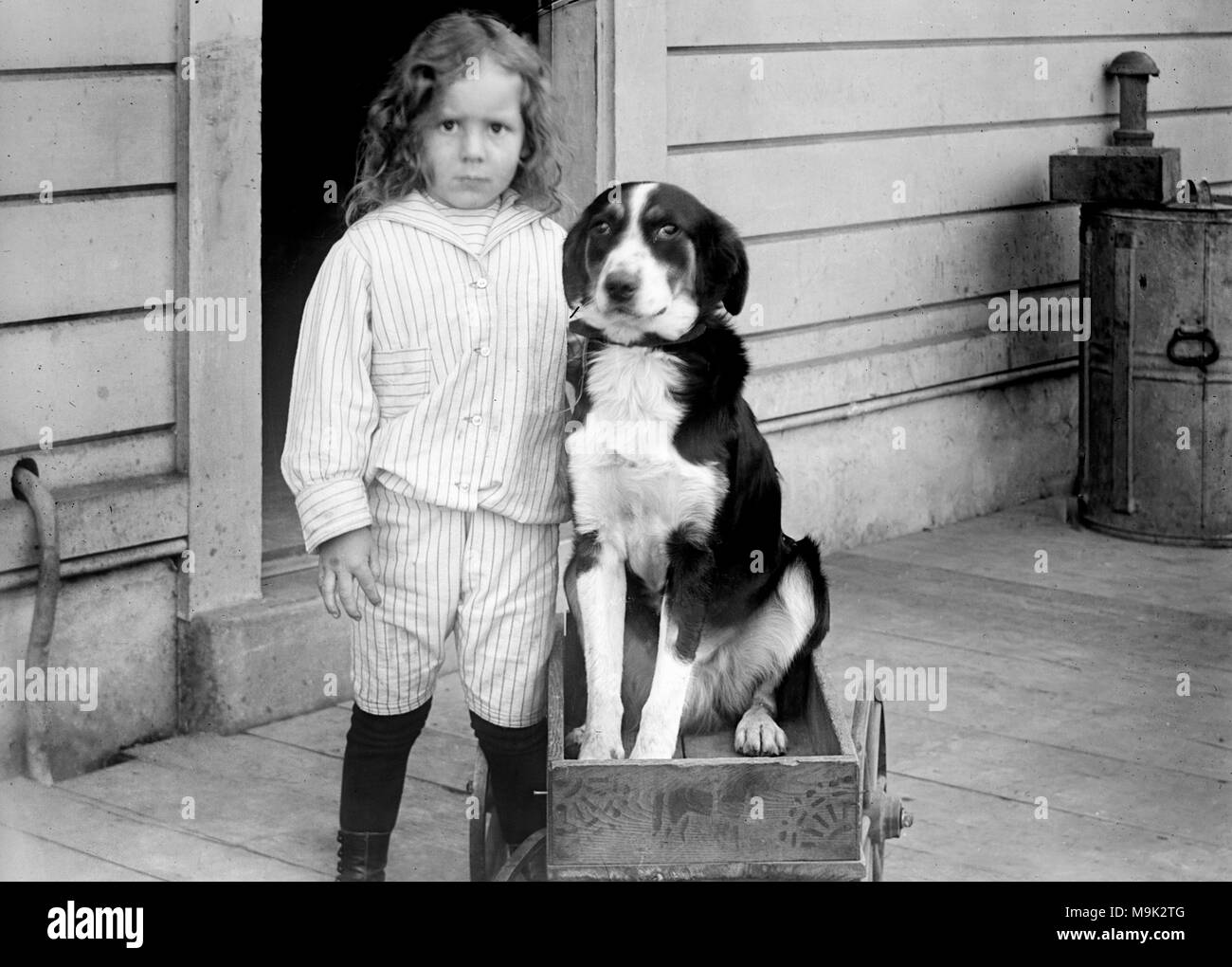 Un jeune garçon se distingue avec son chien perché dans un wagon, ca. 1905. Banque D'Images