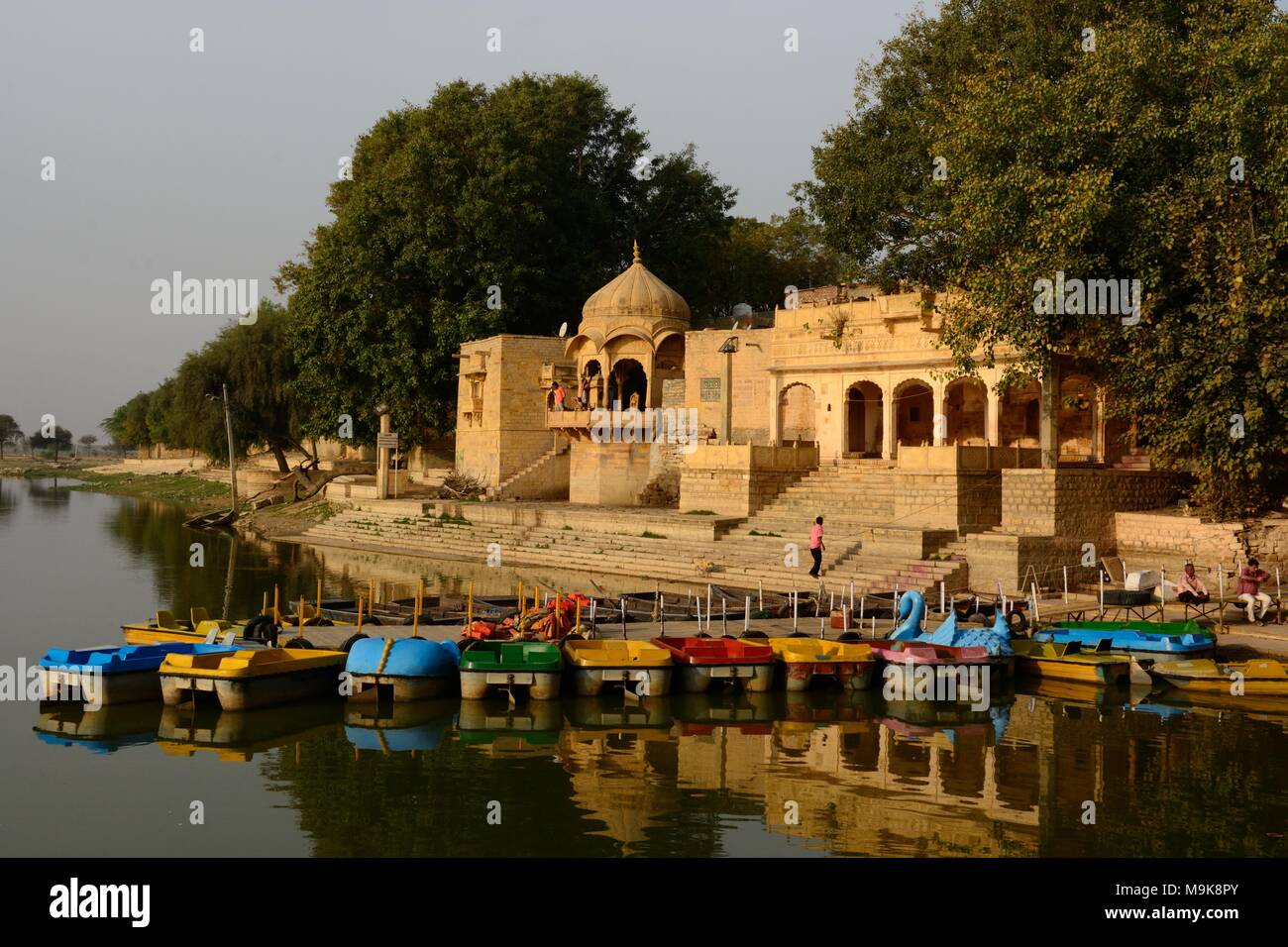 Petits bateaux colorés sur Gadisar lac en face de Temple Gadi Sagar Jaisalmer Inde Rajashan Banque D'Images