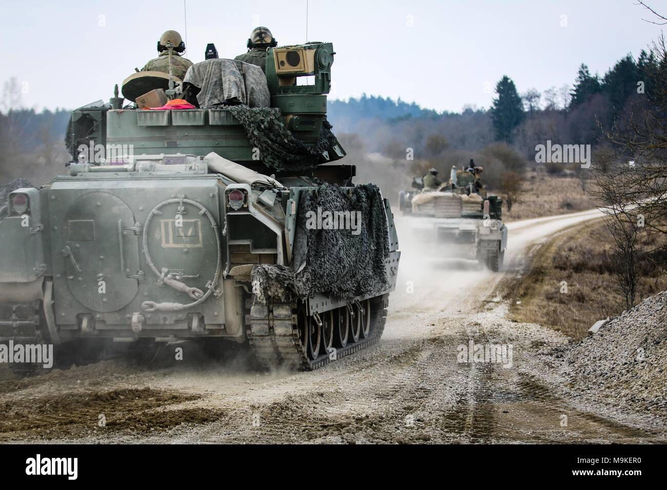 Un véhicule de combat Bradley M2 pistes a M1 Abrams tank, tous deux de la 5e Escadron, 4e régiment de cavalerie blindée, 2e Brigade Combat Team, 1re Division d'infanterie, tout en se déplaçant pour sécuriser une zone au cours d'un exercice de tir réel interarmes (CALFEX) au secteur d'entraînement Grafenwoehr, Allemagne, Mar 26, 2018. (U.S. Photo de l'armée par la CPS. Hubert D. Delany III / 22e Détachement des affaires publiques mobiles) Banque D'Images