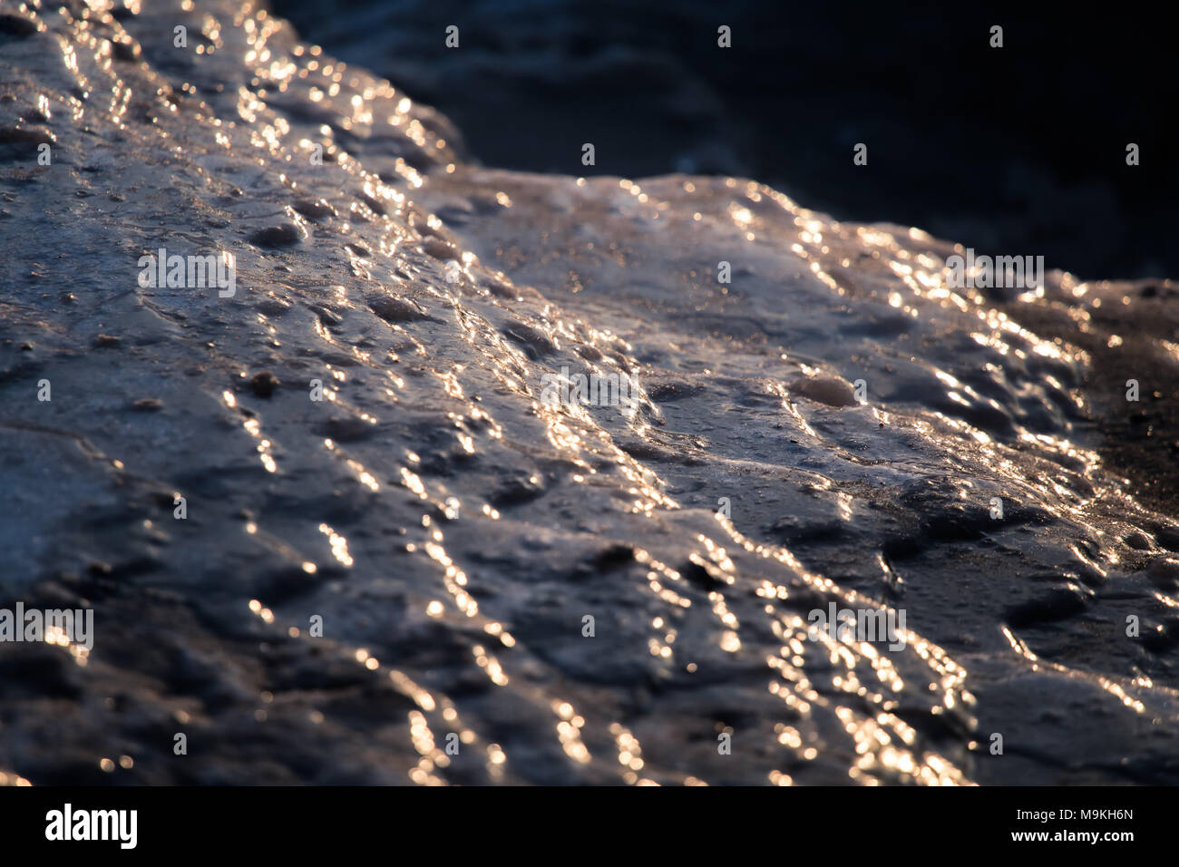 Un beau gros plan d'une eau de mer gelée sur la côte de la mer Baltique. Vagues d'eau salée gelées sur une plage. Gros plan abstrait de glace. Banque D'Images