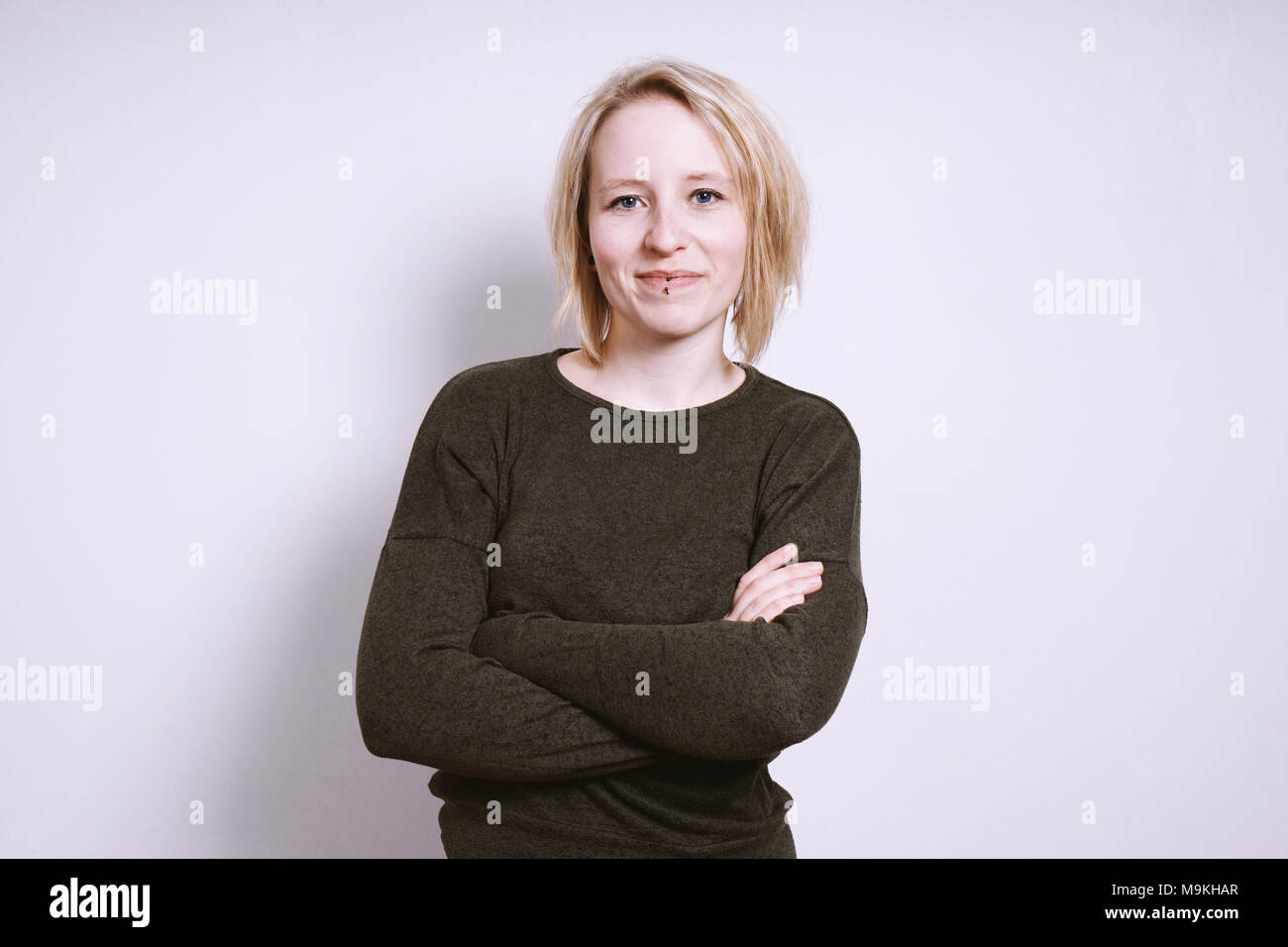 Young blonde woman with arms folded Banque D'Images