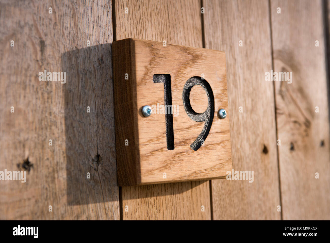 Le nombre dix-neuf carreaux de bois sculpté dans une plaque sur une maison pour montrer l'adresse propriétés Banque D'Images