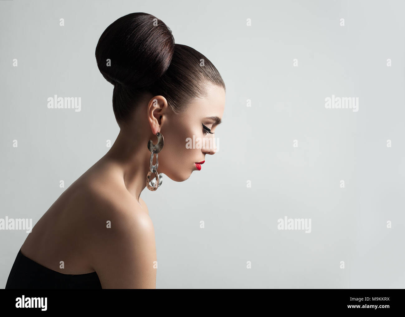 Jolie Jeune femme avec cheveux Bun Coiffure et maquillage Eyeliner. Modèle féminin parfait, Portrait de profil. Banque D'Images