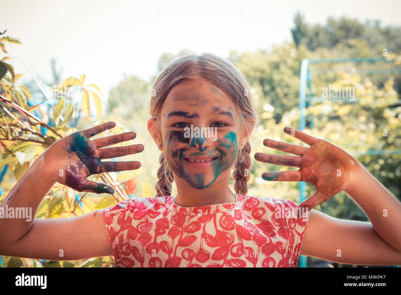 Creative Child girl smiling joyeuse peintre visage peint montrant les mains de jour d'enfant lumineux concept art development Banque D'Images