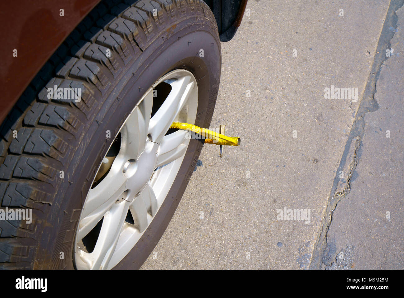 Roue de voiture bloquée par blocage de roue parce que le stationnement  illégal violation Photo Stock - Alamy