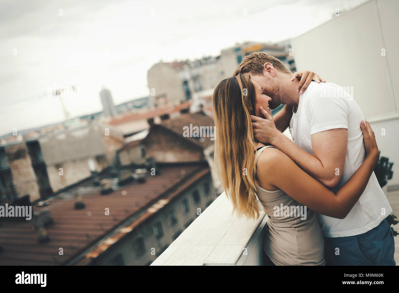 Couple kissing on rooftop Banque D'Images