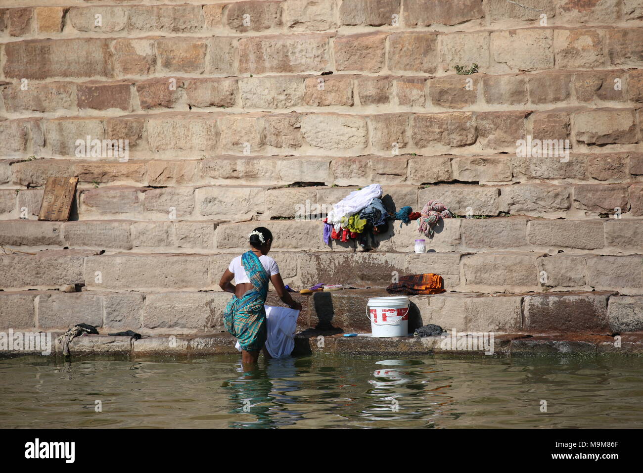 Femme indienne le lavage des vêtements et de la vaisselle sur le fleuve - inderin beim waschen von Kleidung und geschirr am fluss Banque D'Images