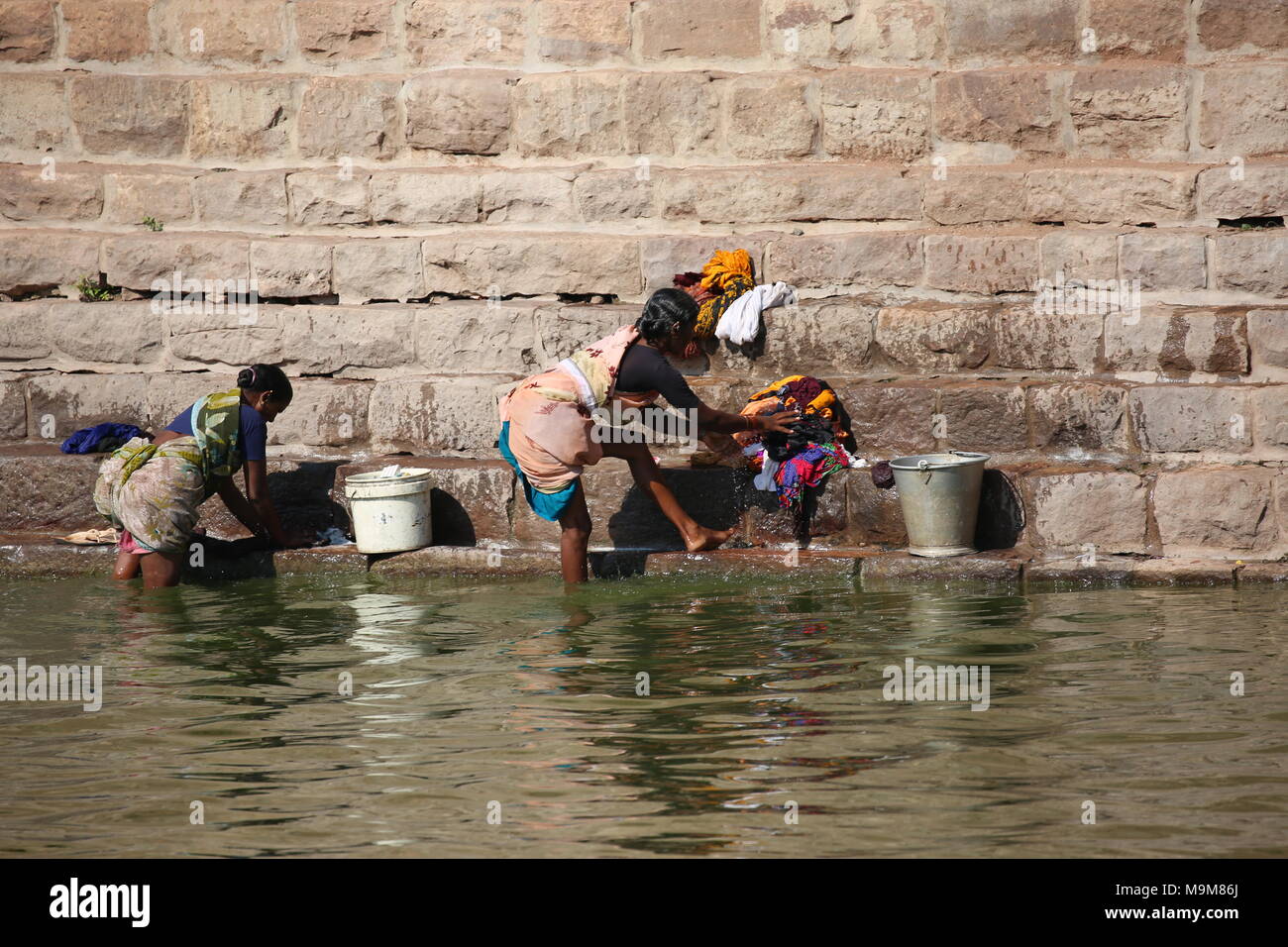 Femme indienne le lavage des vêtements et de la vaisselle sur le fleuve - inderin beim waschen von Kleidung und geschirr am fluss Banque D'Images