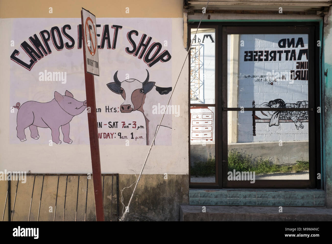 Butcher's signe avec une vache, un cochon et une réflexion à Orange Walk, Belize Banque D'Images