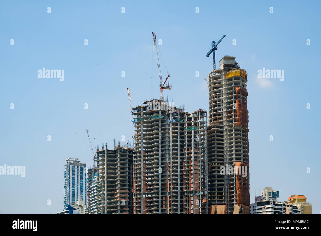 Site de construction du nouveau bâtiment gratte-ciel isolé sur ciel bleu - Banque D'Images