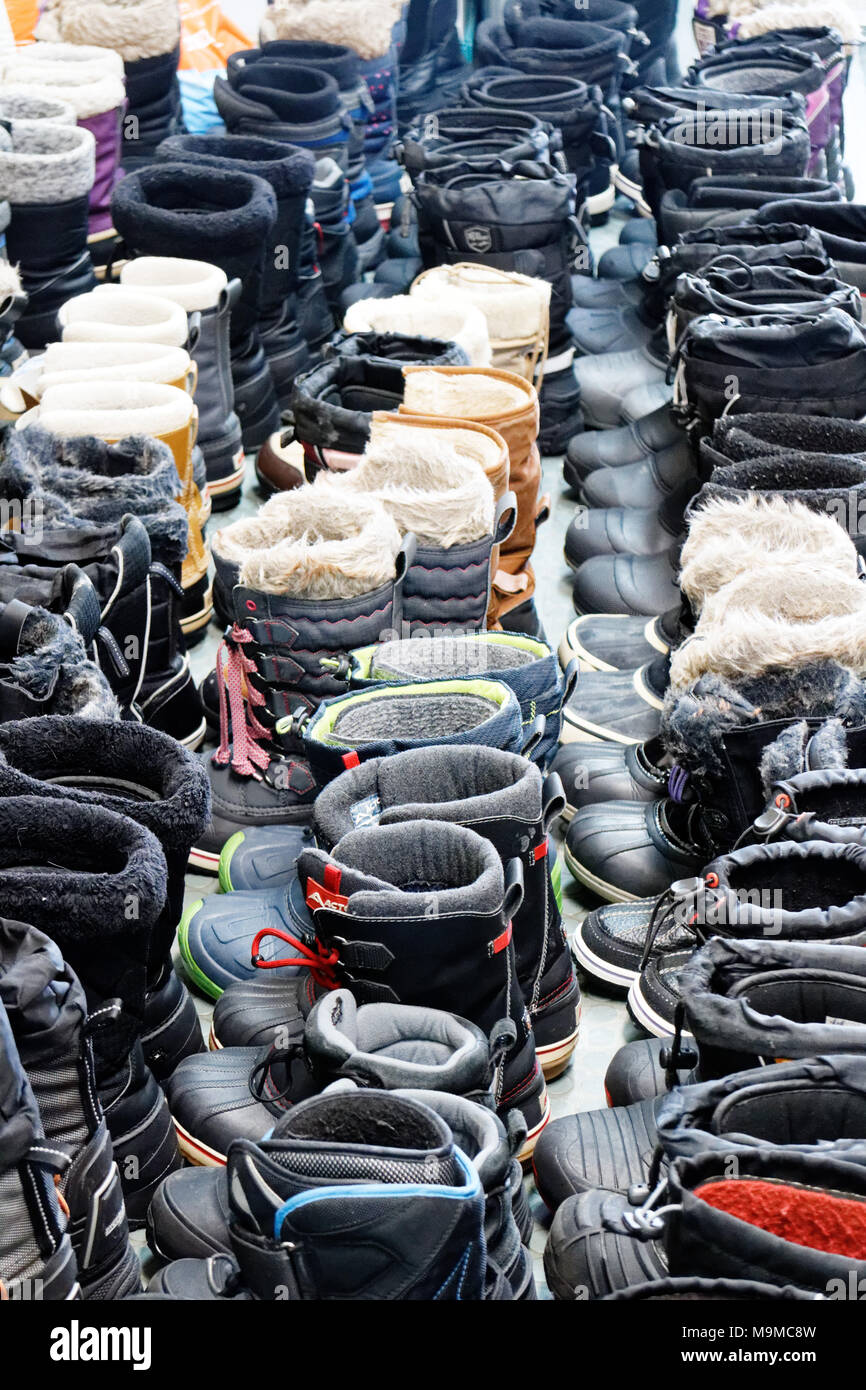 Soixante cinq paires de bottes d'hiver parfaitement alignées dans une station de ski du Québec Banque D'Images