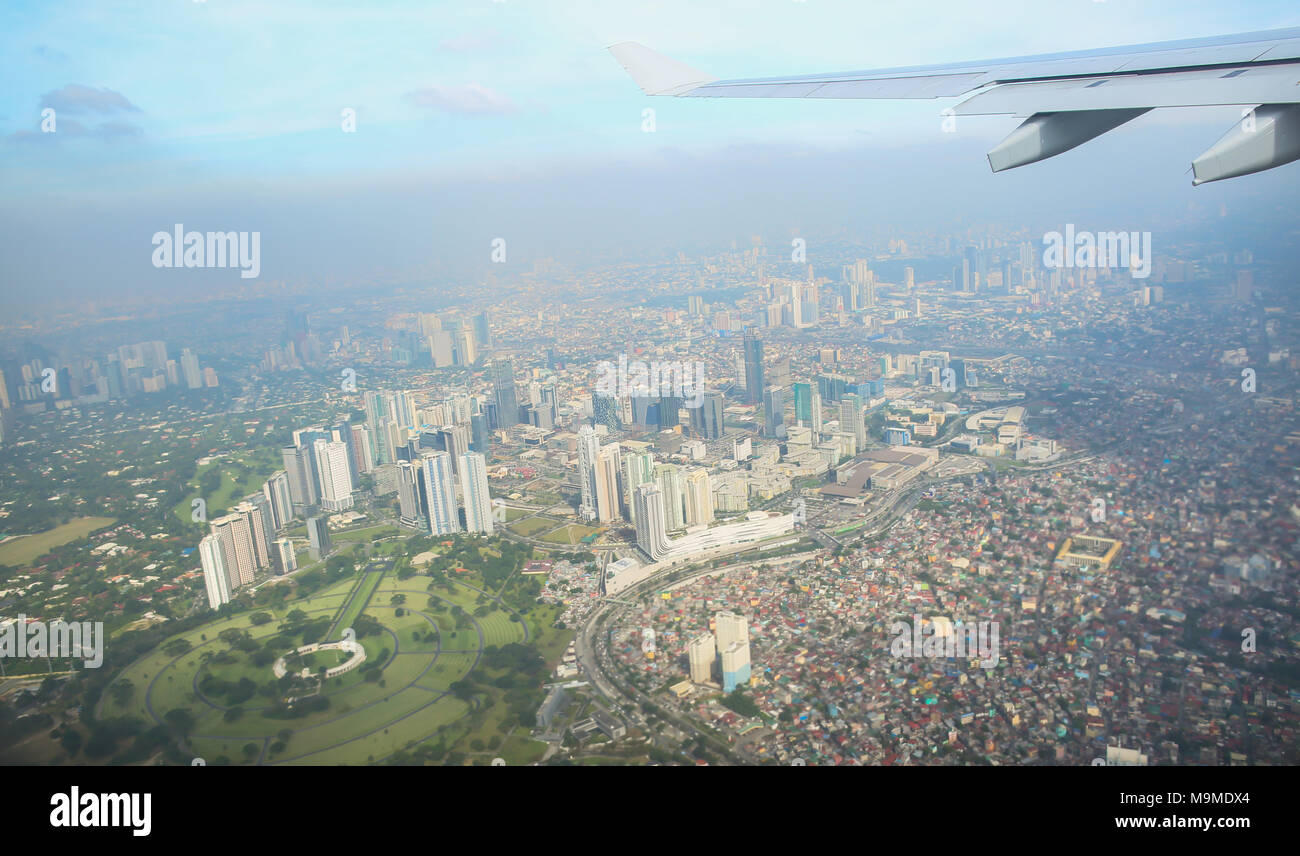 Une vue de la ville de Manille par la fenêtre de l'avion. Impressionné photo d'un séjour touristique en vol au dessus de la capitale. Aux Philippines. Banque D'Images