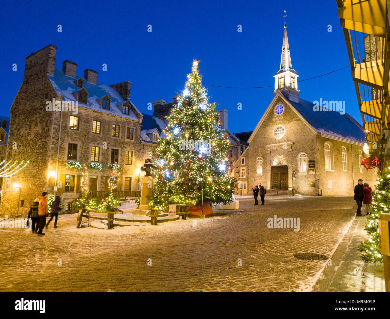 Notre Dame des Victorires et l'arbre de Noël : la petite église dans la section touristique de Québec inférieur avec un grand sapin de Noël allumé sur la place. Regarder les touristes et d'errer. Banque D'Images
