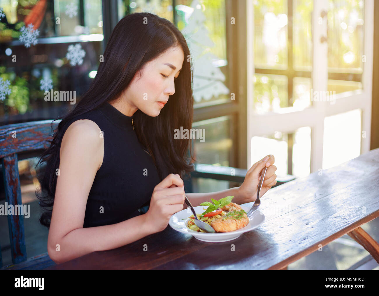 Young woman eating food in a restaurant Banque D'Images