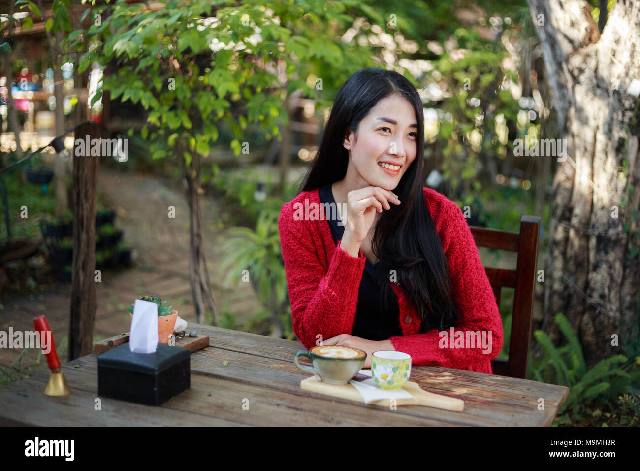 Portrait de belle jeune femme avec un café dans le jardin Banque D'Images