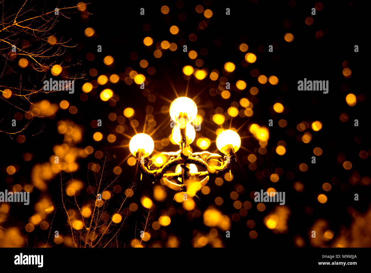 Lanterne antique la nuit avec des flocons de neige tombant en premier plan. Banque D'Images