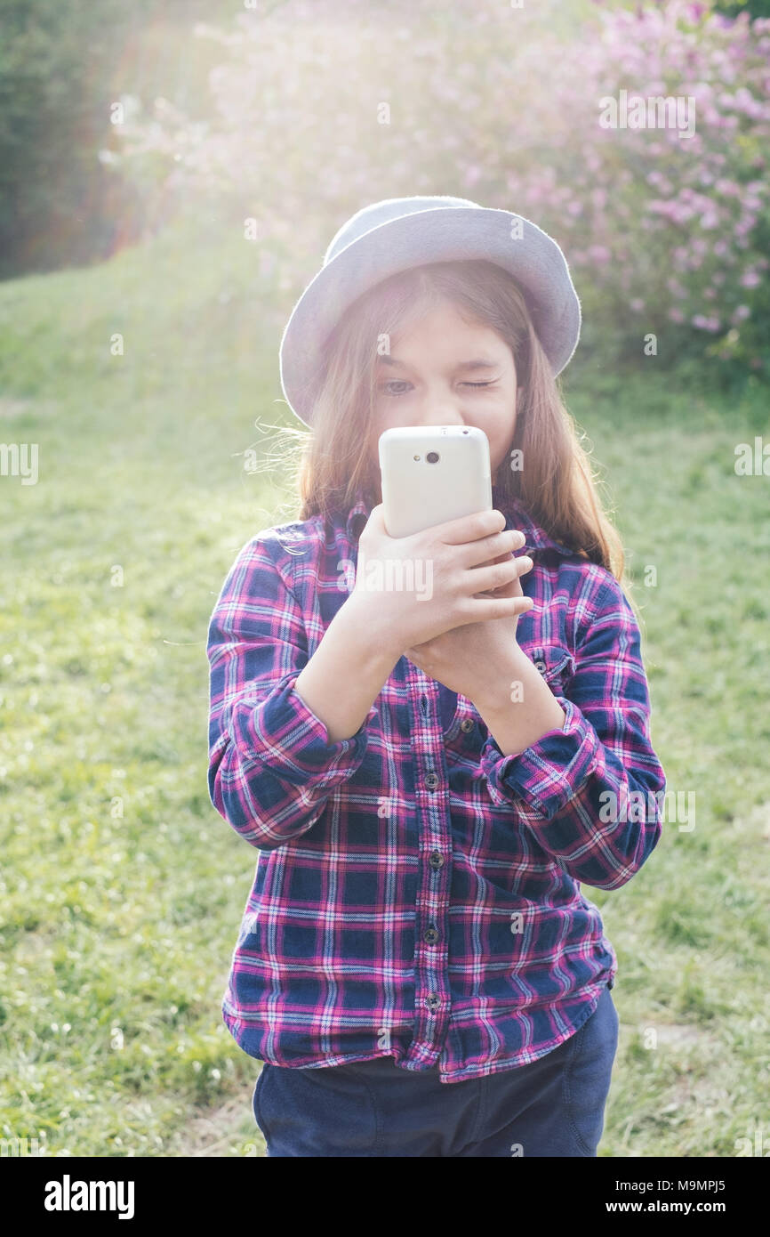Pr ado adorable brunette tweenie kid fille avec son smartphone