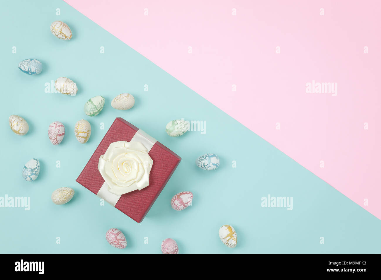 Vue de dessus tourné d'arrangement Joyeuses Pâques décoration fond de concept.Télévision jeter œufs de Pâques colorés avec boîte-cadeau sur papier bleu & rose moderne Banque D'Images