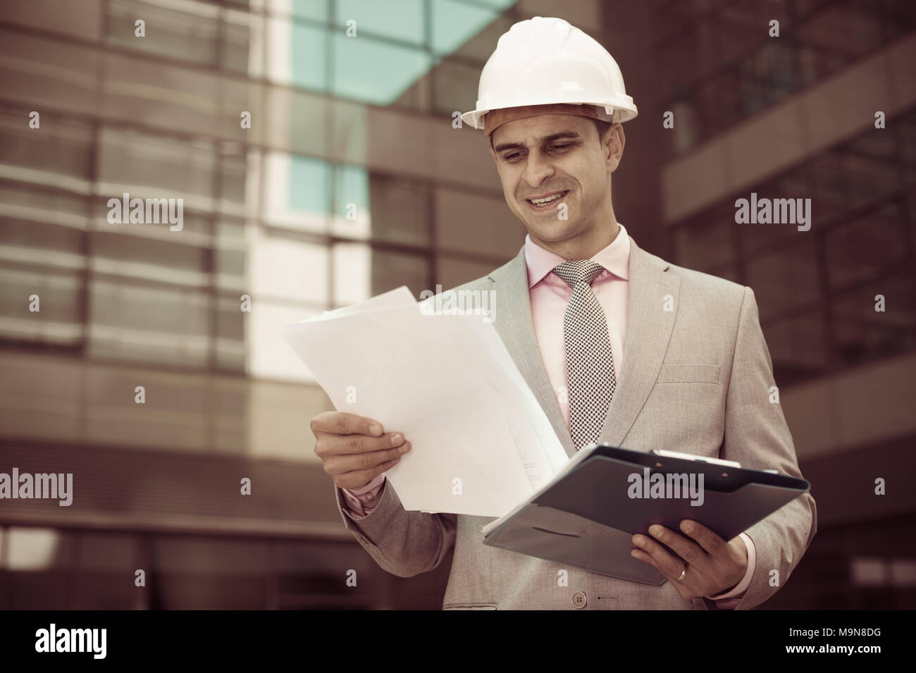 Businessman holding folder avec des documents et de contentement lecture Banque D'Images