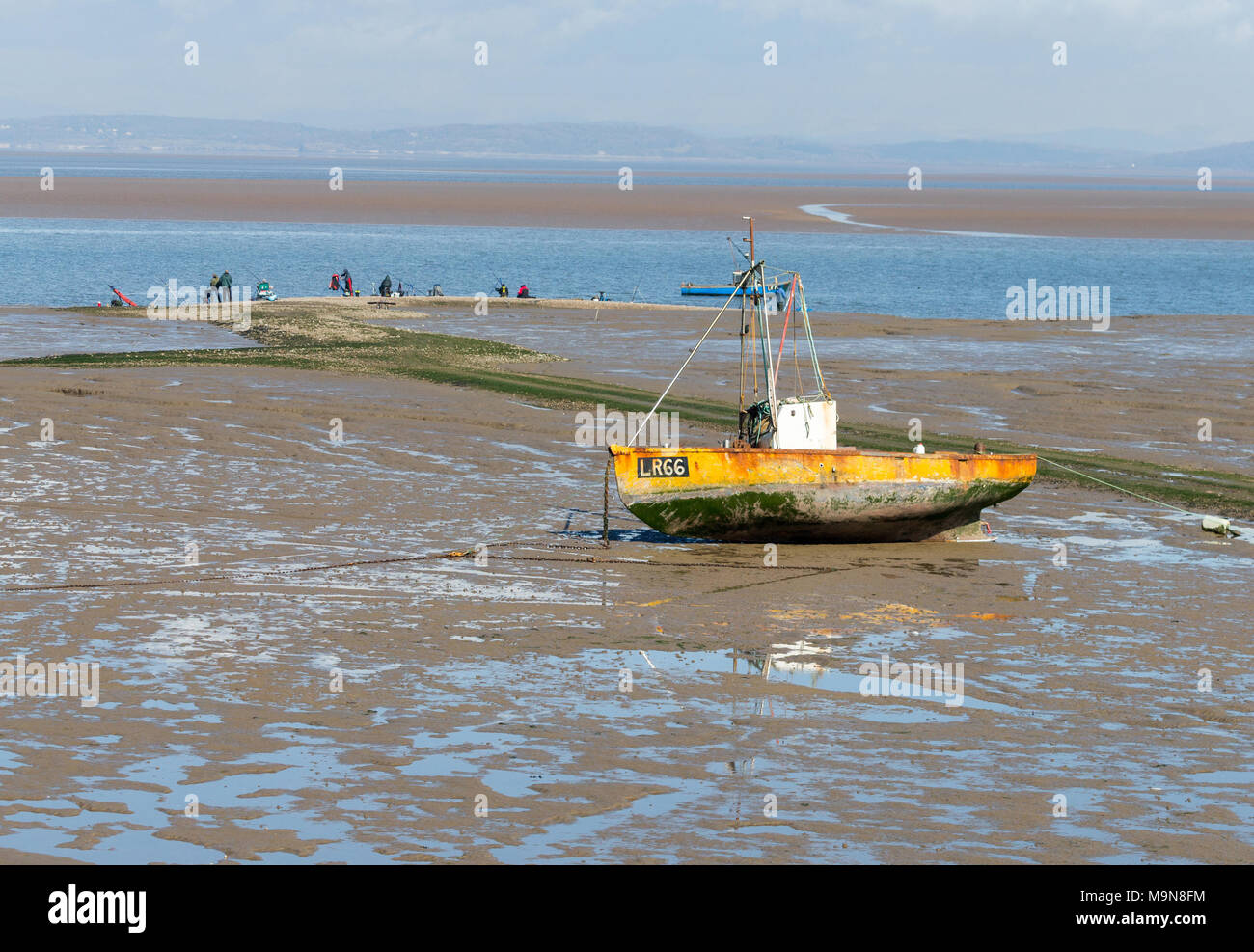 Un petit bateau de pêche côtière est échoué abandonné à Morecambe, England, UK Banque D'Images