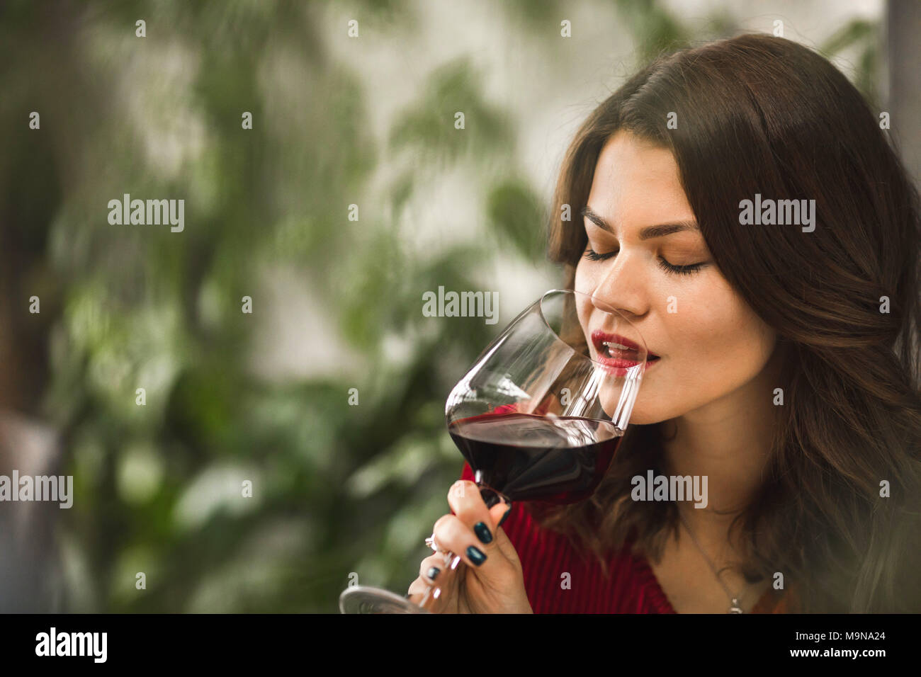 Un vin rouge d'une belle jeune fille sip Banque D'Images