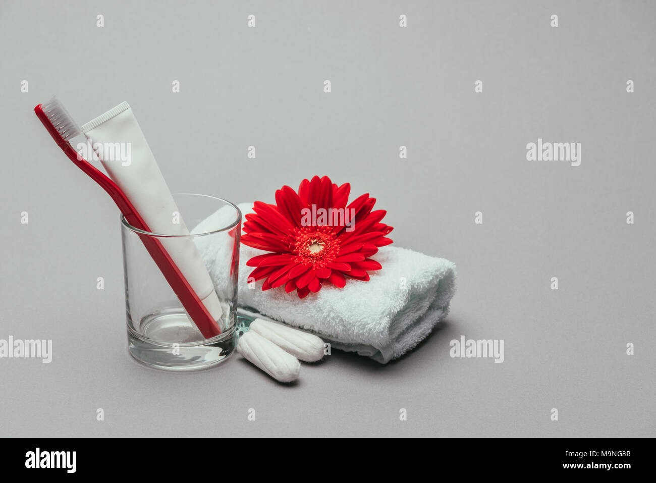 Vue en gros de fournitures d'hygiène, fleur et serviette isolé sur gray Banque D'Images