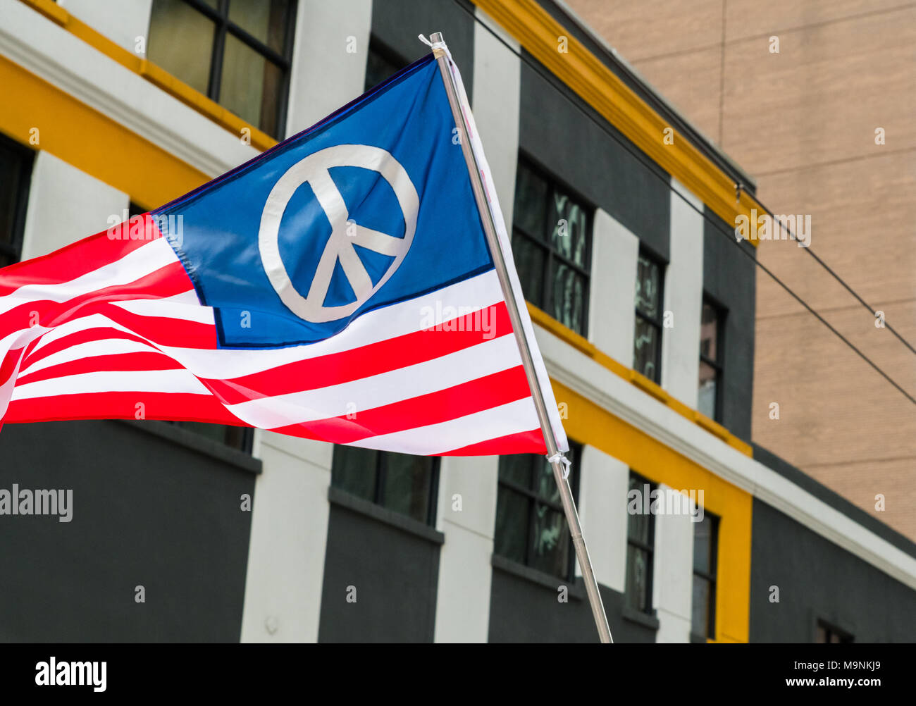 Un drapeau américain conçu avec un symbole de paix vole pendant la marche pour notre vie manifestations à Houston Banque D'Images