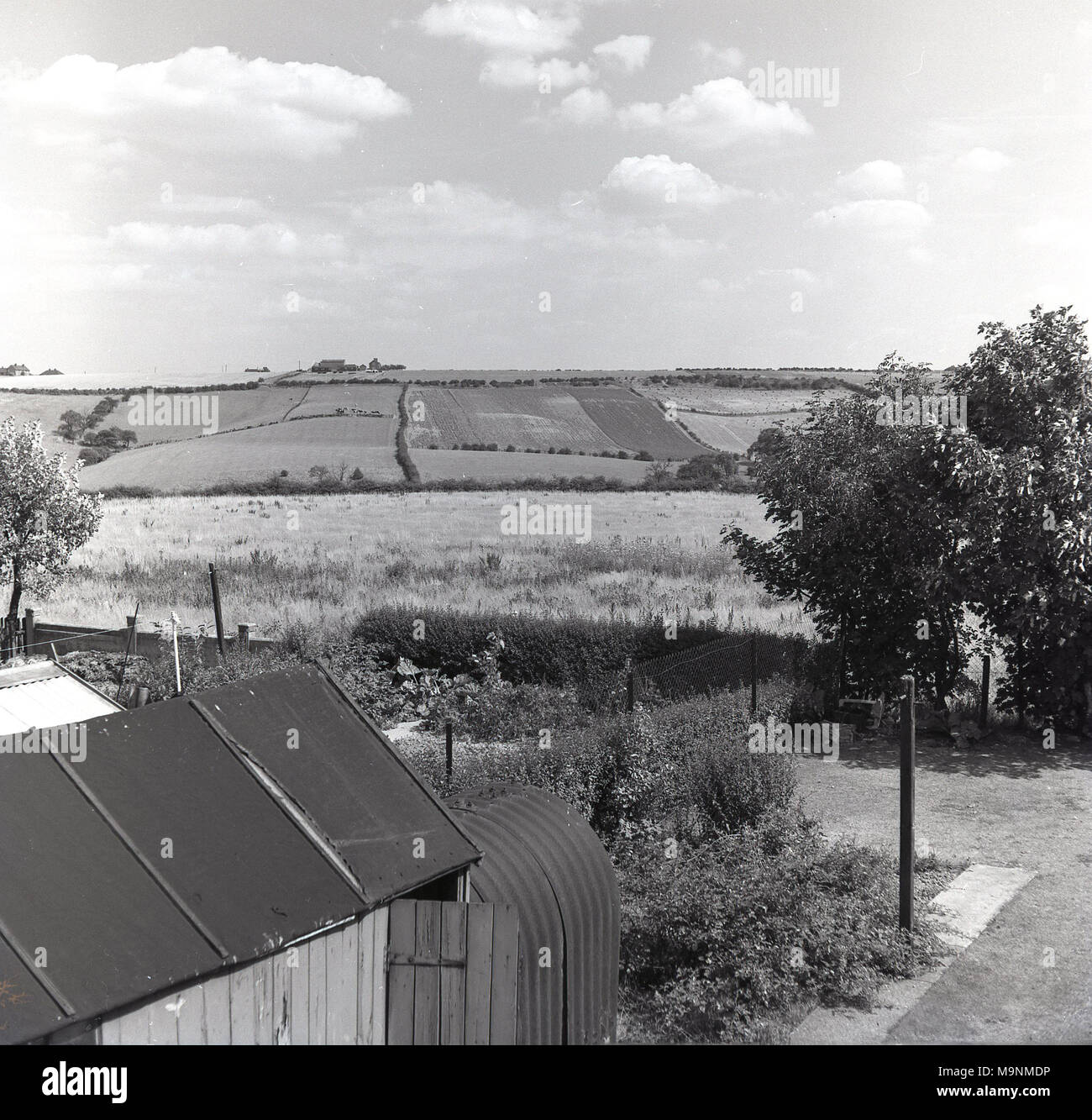 Années 1960, historique, vue sur champs, vieux pays montrant WW2 planelled métal (acier) air-raid bunker ou Anderson à l'abri dans le jardin arrière, Manchester, Angleterre, Banque D'Images