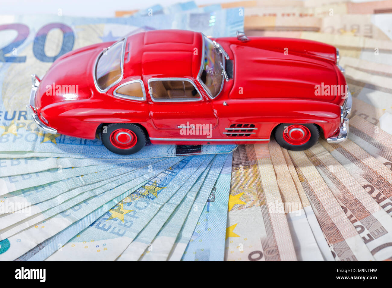 Une voiture de sport classique de l'année 1954 de couleur rouge sur l'introduction des billets avec fond blanc. Banque D'Images