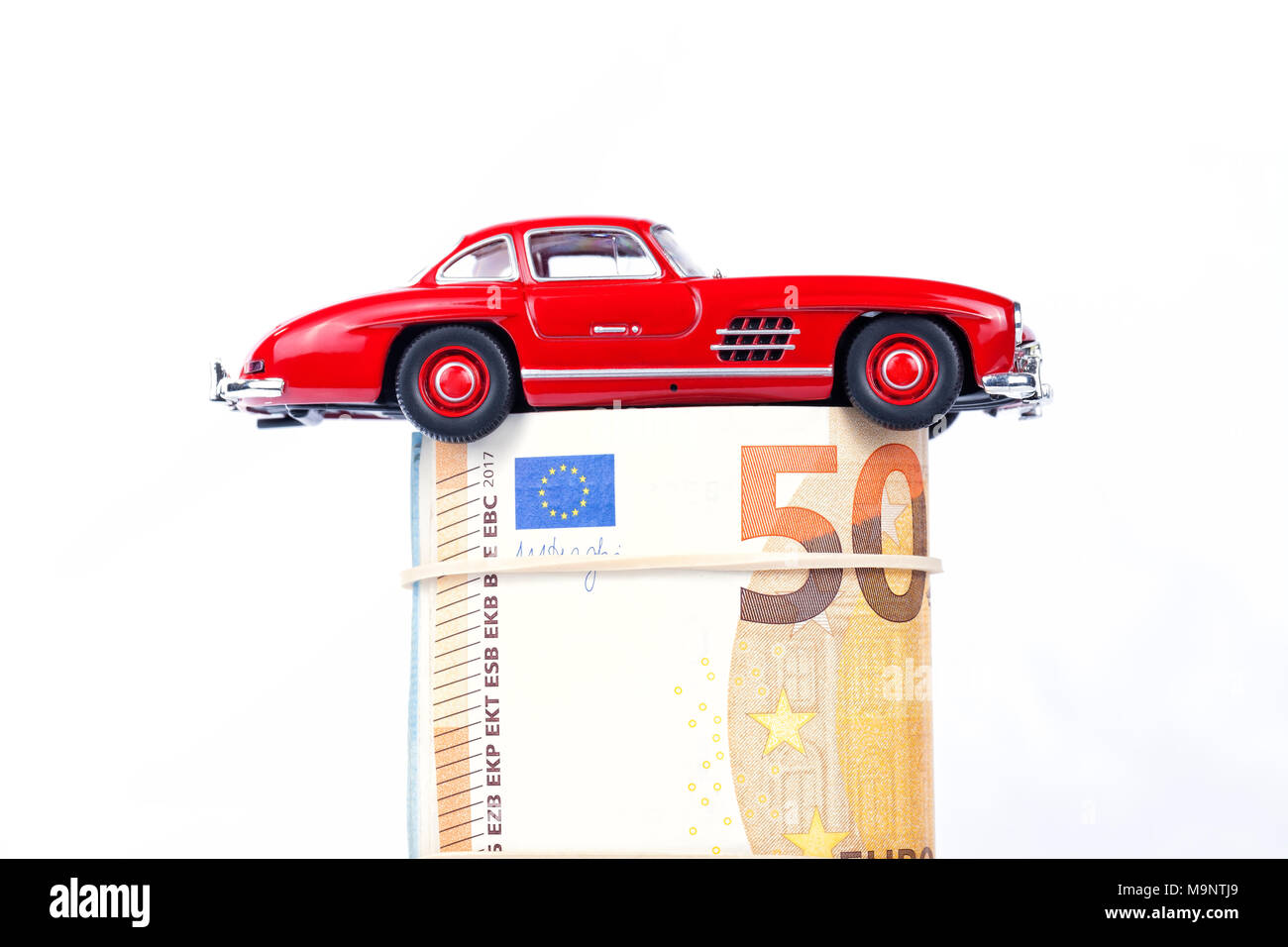 Une voiture de sport classique de l'année 1954 de couleur rouge sur l'introduction des billets isolé sur fond blanc. Banque D'Images