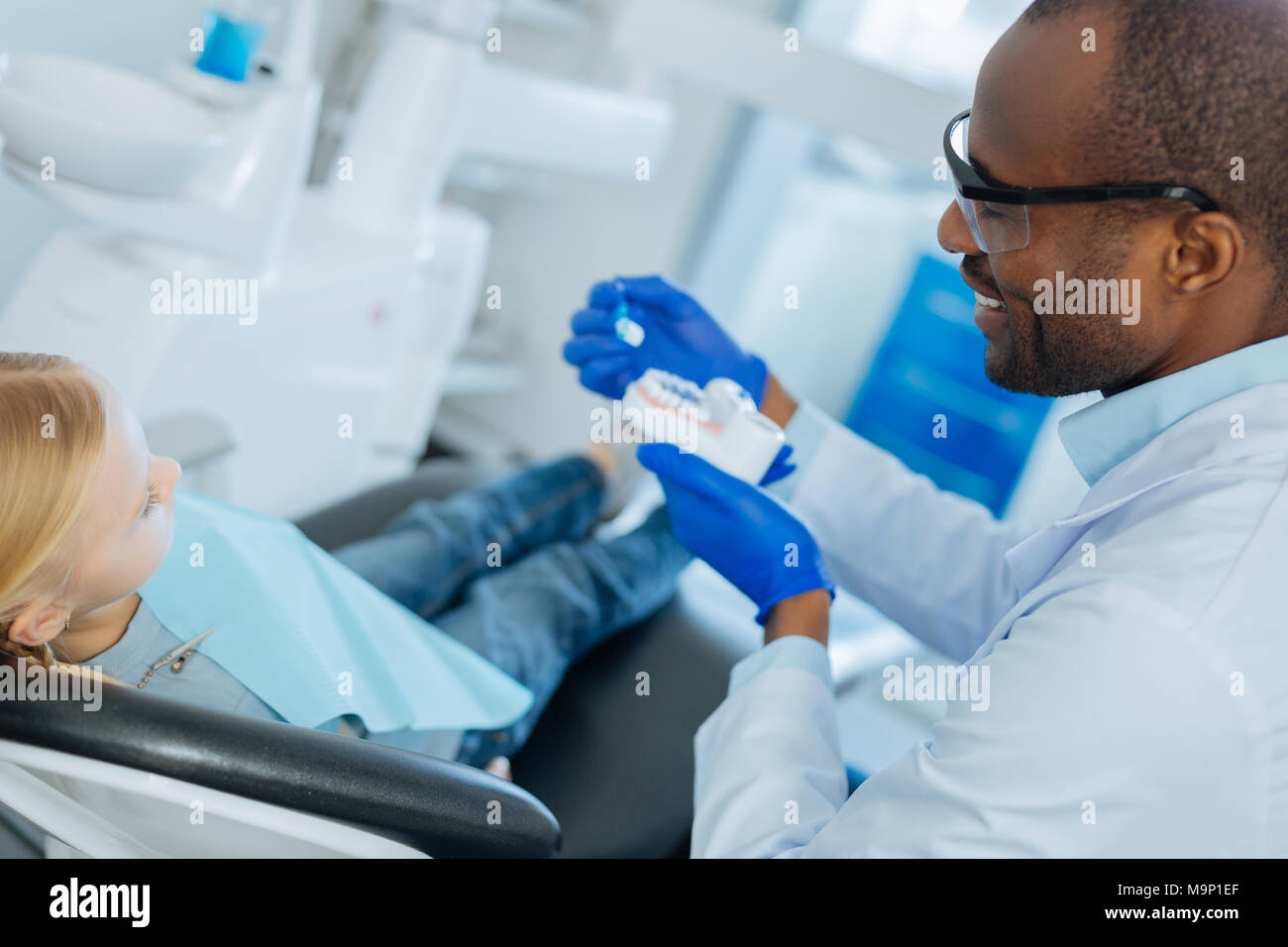 Male dentist showing algorithme correct de nettoyer les dents Banque D'Images