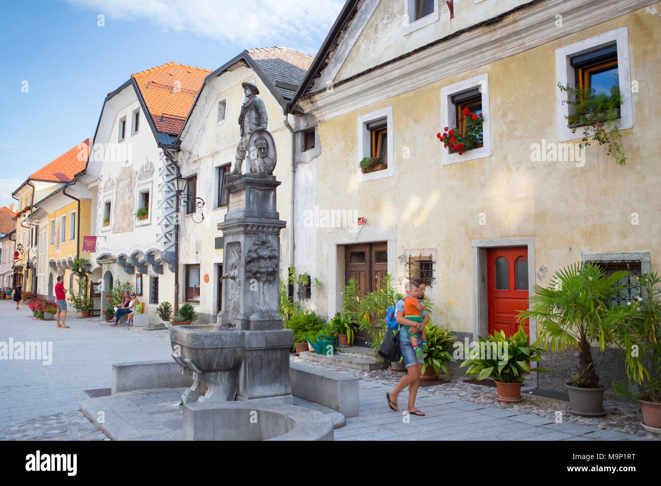 Femme portant enfant sur Linhartov Trg, la place principale de couleur de Radovljica, Slovénie Banque D'Images
