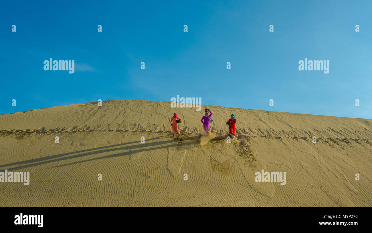 Les femmes sont Cham walking on sand dunes in Nam Cuong, Phan Rang, Viet Nam Banque D'Images