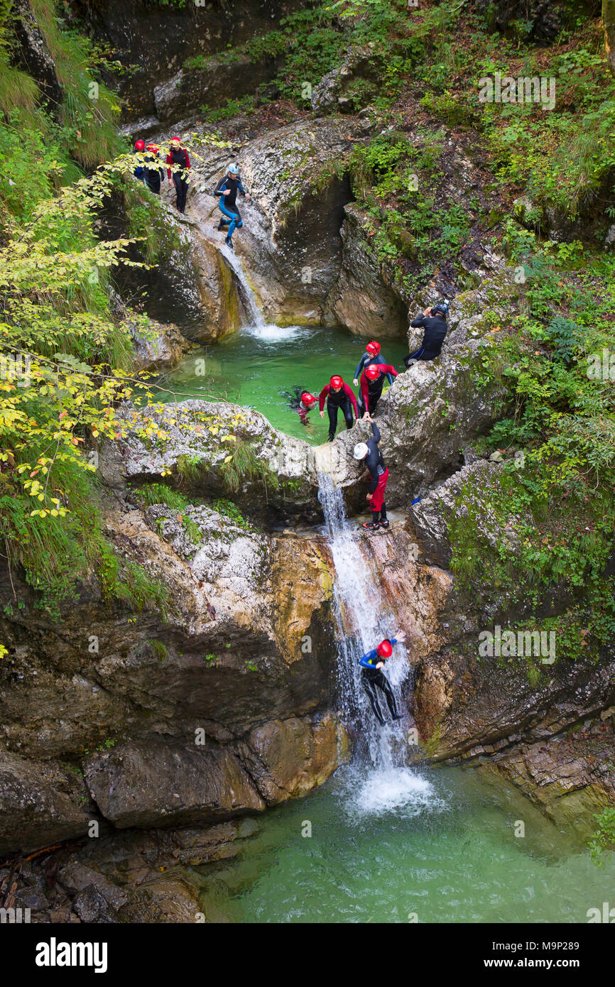 Canyoning dans une gorge étroite remplie de rapids, piscines et cascades dans la vallée de Soca près de Bovec, Slovénie. Banque D'Images
