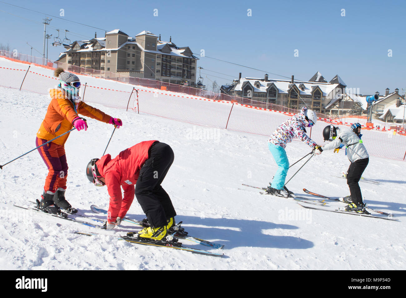 Deux femmes apprennent à skier sur une pente de ski de l'Alpensia resort dans la région du Gangwon-do en Corée du Sud. L'Alpensia Resort est une station de ski et une attraction touristique. Il est situé sur le territoire du canton de Daegwallyeong-myeon, dans le comté de Pyeongchang, hébergeant les Jeux Olympiques d'hiver en février 2018. La station de ski est à environ 2,5 heures à partir de l'aéroport d'Incheon à Séoul ou en voiture, tous principalement d'autoroute. Alpensia possède six pistes de ski et snowboard, avec fonctionne jusqu'à 1.4 km (0,87 mi) long, pour les débutants et les skieurs avancés, et une zone réservée aux Banque D'Images