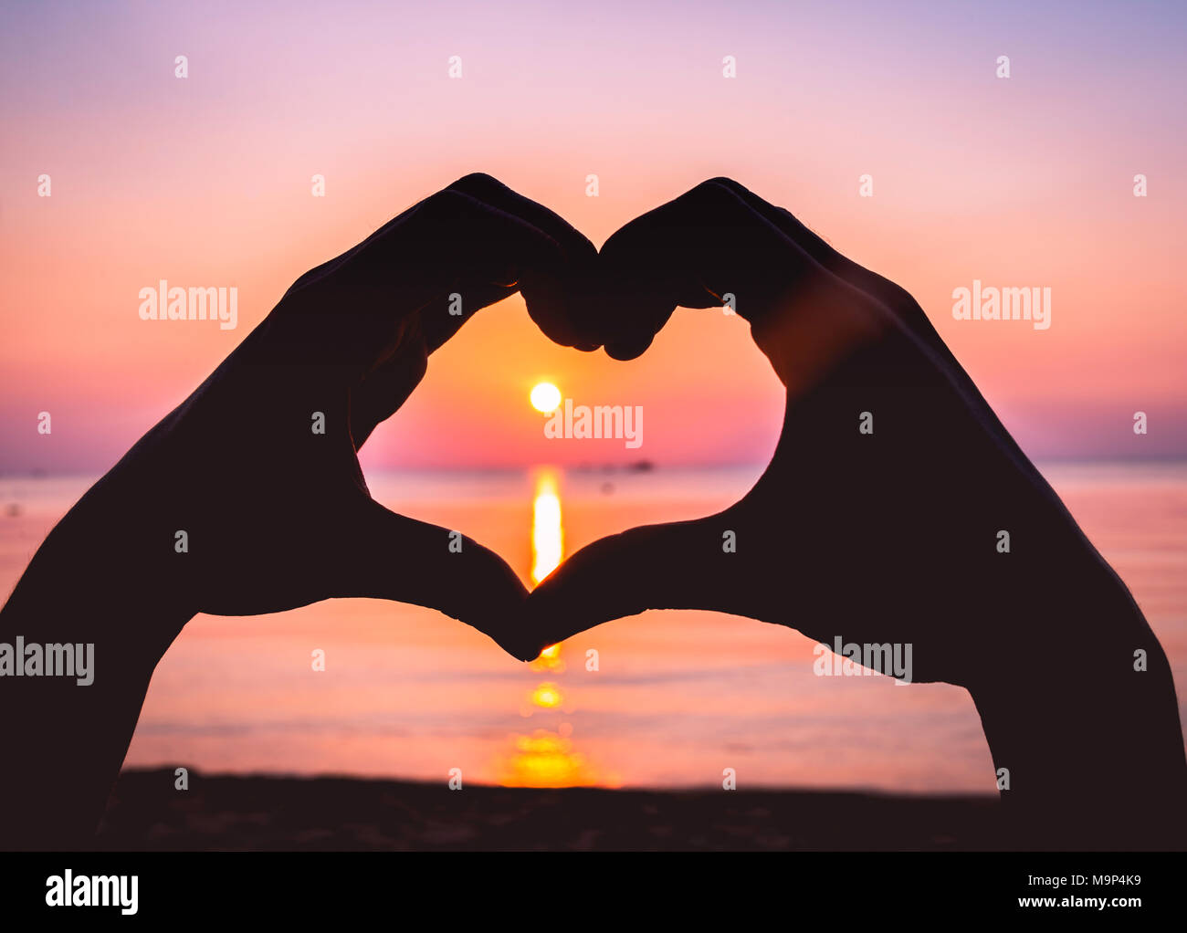 Mains former un coeur, silhouette d'un coeur contre la lumière, le coucher du soleil sur la plage, Ko Pha-ngan, Golfe de Thaïlande, Thaïlande Banque D'Images