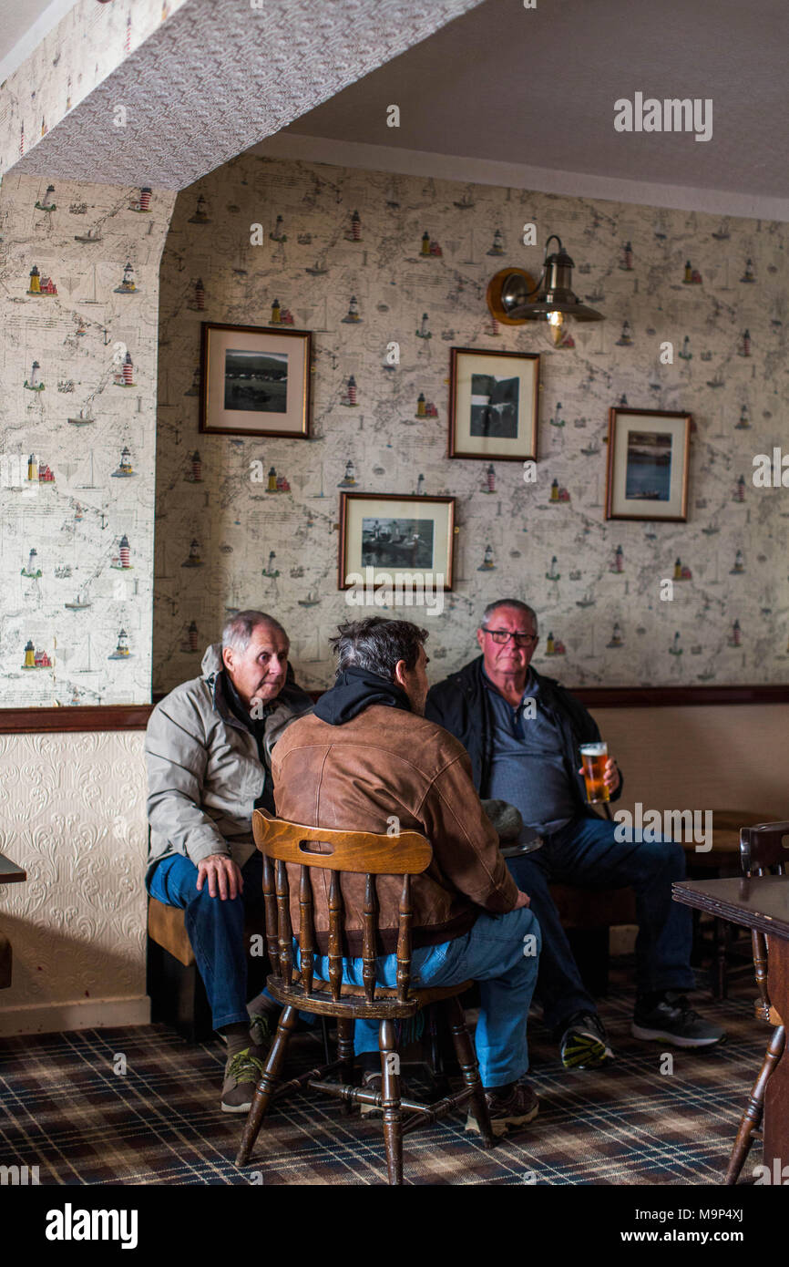 Trois hommes appréciant pinte au pub local, Portree, Isle of Skye, Scotland, UK Banque D'Images