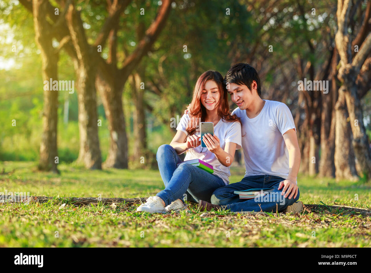 Couple à l'aide de téléphone mobile dans le parc Banque D'Images