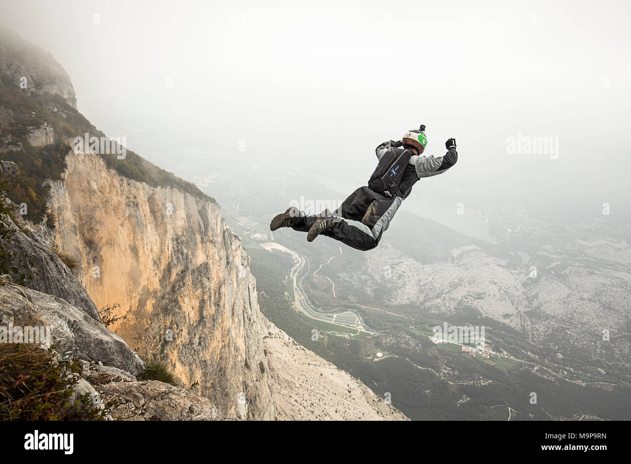 Cavalier Base mid air juste après cliff jump pendant temps de brouillard, Brento, Vénétie, Italie Banque D'Images