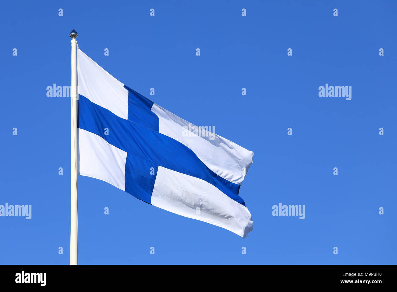 Drapeau national de la Finlande contre le ciel bleu. Banque D'Images