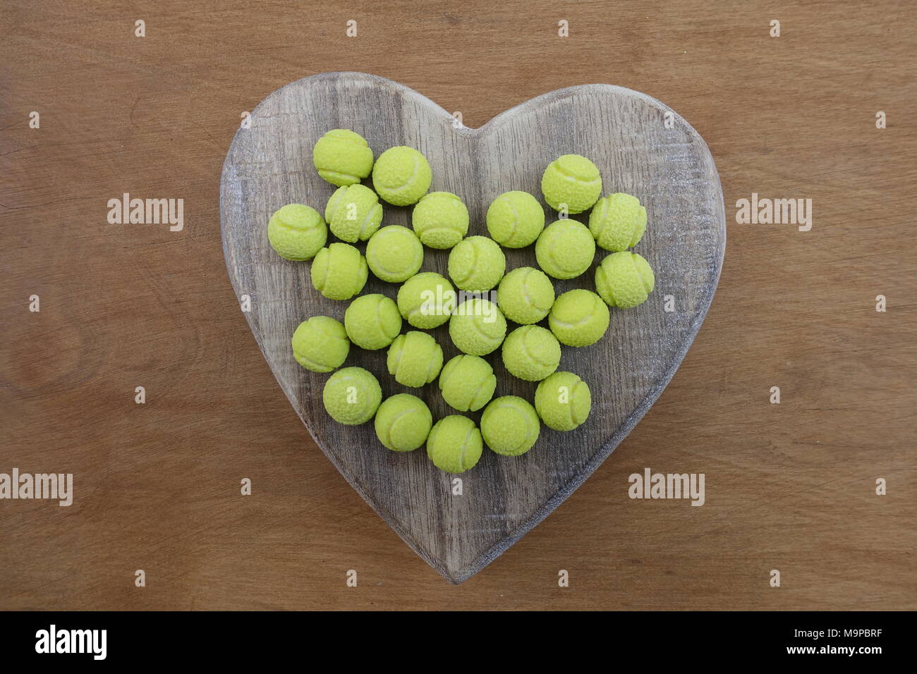 Balle de tennis jaune sur un coeur en bois bonbons Photo Stock - Alamy