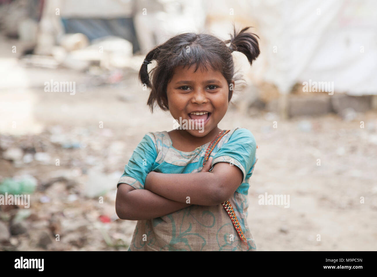 Happy little girl dans le bidonville au dépotoir de Ghazipur, New Delhi, Inde Banque D'Images