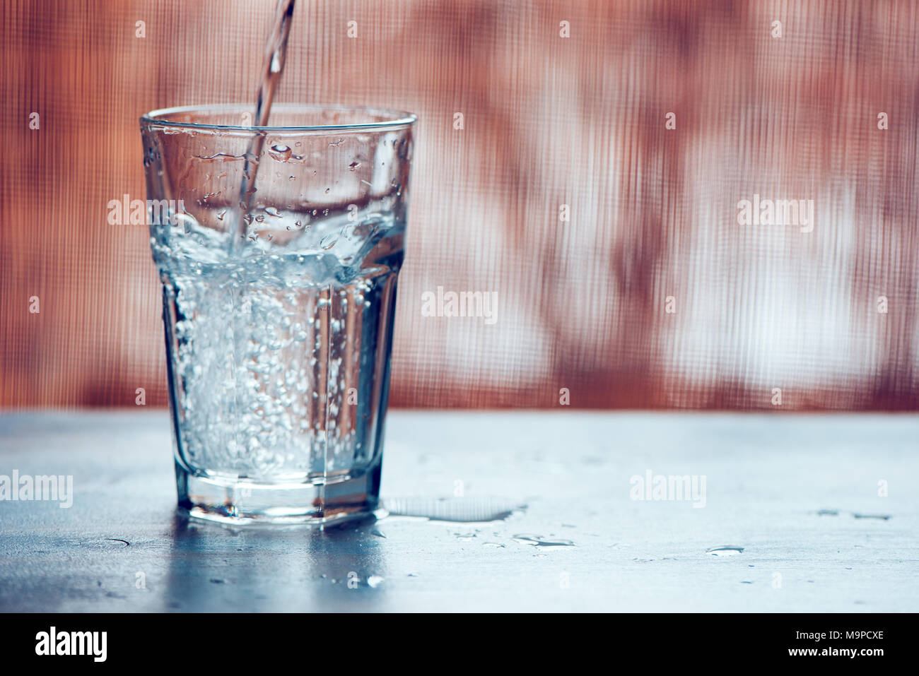 Verser l'eau gazeuse fraîche en verre sur la table, selective focus Banque D'Images