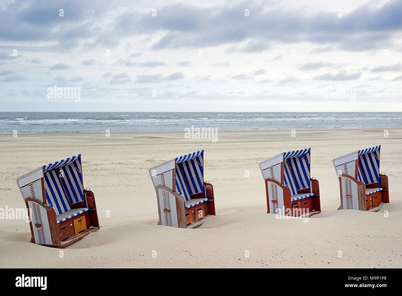 Chaises de plage sont côte à côte dans le sable sur la plage, Norderney, îles de la Frise orientale, mer du Nord, Basse-Saxe, Allemagne Banque D'Images